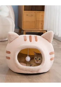 Cozy semi-enclosed pink cat head shaped plush pet bed in a warm home interior setting.
