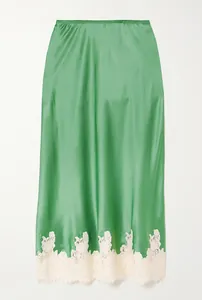 Elegant detail showing the smooth green satin fabric and white lace trim of this skirt
