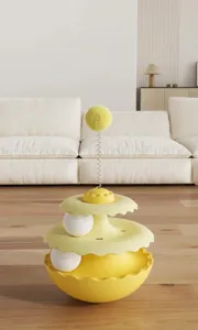 Detailed view of yellow interactive tumbler cat toy with spring-mounted plush ball