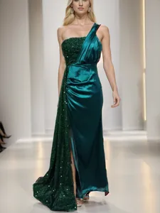 Elegant emerald green one-shoulder evening gown featuring sequined and satin draping details.