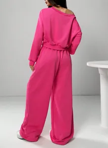 Vue arrière d'une femme en sweat rose fuchsia à épaules dénudées et pantalon large
