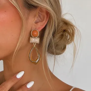 Detalle de pendientes vintage de acrílico con resina de ámbar en modelo rubia