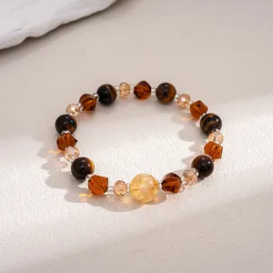 Close-up detail of tiger eye stone and amber glass beads on a vintage beaded bracelet.