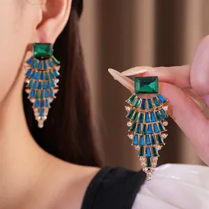Statement-Ohrringe mit grünen und blauen Kristallen und fächerförmigem Design.