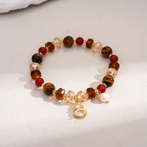 Close-up of retro tiger eye and glass beaded bracelet with a crystal gourd pendant.