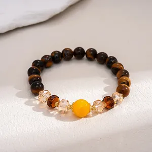 Macro detail of vintage tiger eye stone and glass beaded bracelet on a textured stone surface