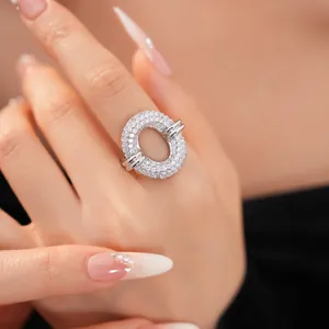 Close-up detail of a silver oval hollow ring encrusted with cubic zirconia stones