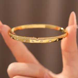 Gros plan d'un bracelet jonc luxueux plaqué or 18 carats avec zircons.
