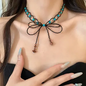 Collana a fiocco di perline con accenti turchesi e nappe in pietra, stile sweet cool.