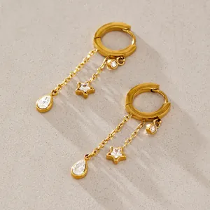 Detailed macro view of gold stainless steel hoop earrings with star and teardrop charms.