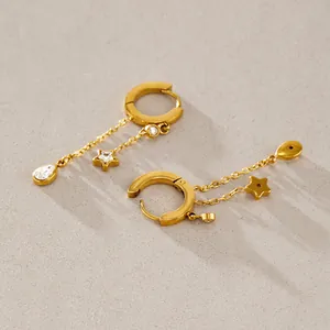 Macro view of gold stainless steel hoop earrings with hanging star and teardrop