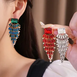 Nahaufnahme von großen Strass-Ohrringen in Fächerform in Rot, Blau und Weiß.