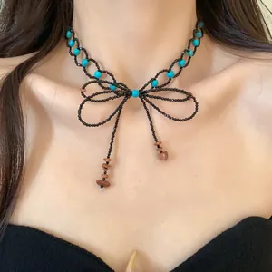 Dettaglio del choker a fiocco con perline, turchese e nappe in stile dolce e alla moda