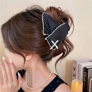 Elegant black polka dot hair claw clip with scalloped lace edges on hair.