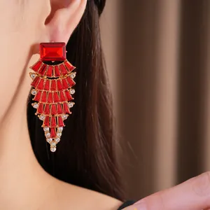 Nahaufnahme von glamourösen roten Strass-Ohrhängern in Fächerform, die am Ohr getragen werden.