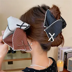 Detail view of elegant polka dot triangle hair claw clips with lace edges