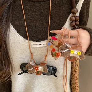 Détail d'un collier porte-lunettes avec chien floqué mignon et cordon en cuir souple
