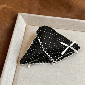Close-up of black and white polka dot triangle hair claw clip with lace trim