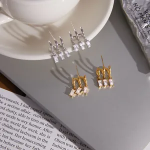 Detailansicht von Edelstahl-Ohrsteckern in Gold und Silber mit glänzenden Zirkonia-Steinen
