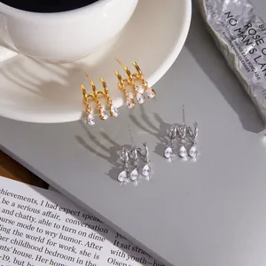 Detailansicht von Edelstahlohrringen mit birnenförmigen Zirkonia in Gold und Silber.