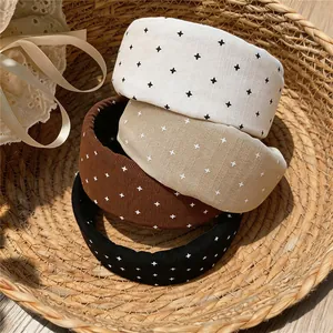 Detail of four padded cloth headbands with printed cross patterns in a woven basket