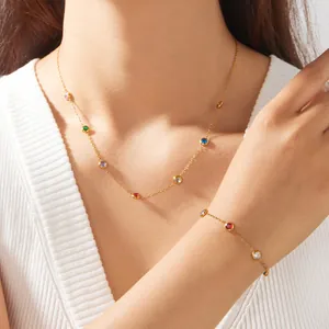 Detailansicht eines vergoldeten Schmucksets mit bunten Zirkoniasteinen an einem Modell getragen.
