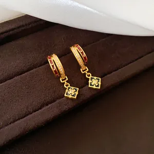 Detail von 24K vergoldeten Creolen mit rotem Emaille- und Zirkonia-Blumenanhängern