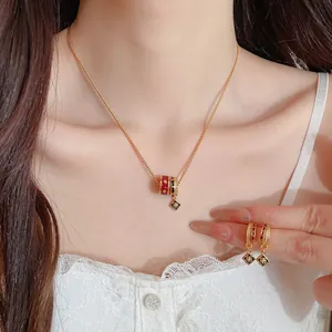 Detailansicht eines vergoldeten Schmucksets mit Emaille-Blumenanhängern und Zirkonia