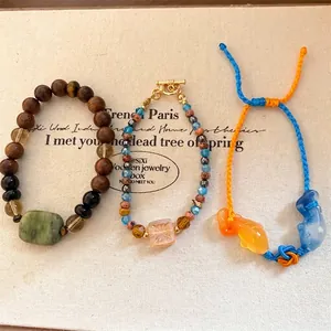 Armbandenset in nieuwe Chinese stijl met houten kralen en gevlochten koiviskoordjes in felle kleur.