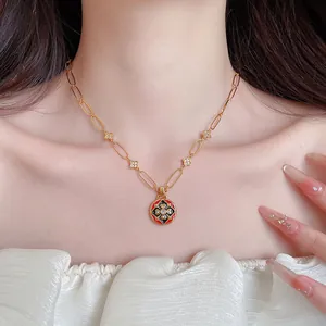 Makro-Detail einer 24K vergoldeten Halskette mit Vintage-Emaille-Blumenanhänger und Zirkon