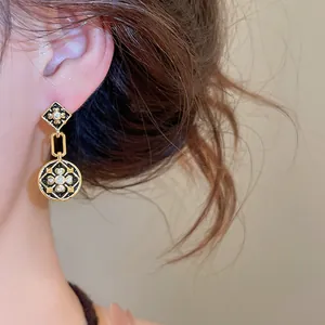 Detailansicht der vergoldeten Vintage-Ohrhänger mit Emaille-Blumenmuster und Zirkon.