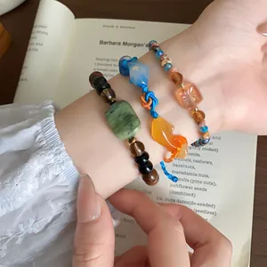 Close-up van drie elegante Chinese gevlochten koikarper-armbanden om de pols gedragen