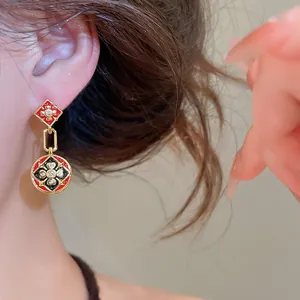 Detailansicht der vergoldeten Emaille-Ohrringe mit Zirkonia-Blumenmotiven.