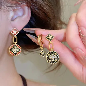 Nahaufnahme von vergoldeten Vintage-Blumenohrringen mit Emaille und Zirkonia-Steinen.