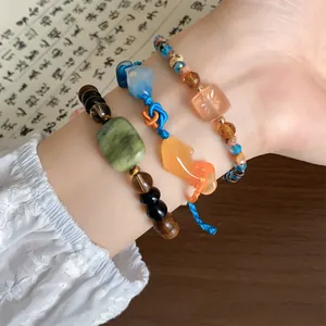 Detailweergave van geweven koi-armbanden in nieuwe Chinese stijl met houten kralen.