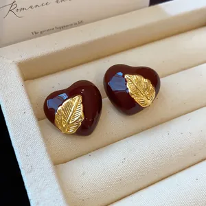 Retro burgunderrote Emaille-Herzohrstecker mit goldenem Blattakzent auf Schmuckdisplay