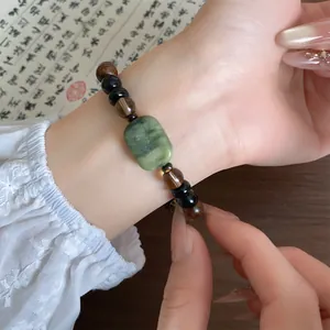 Detailopname van een armband in nieuwe Chinese stijl met groene steen en houten kralen