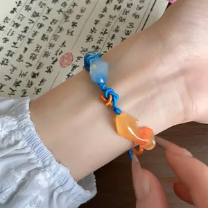 Detailopname van een geweven koi-armband in nieuwe Chinese stijl met blauw koord