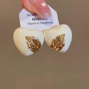 Detailansicht der 18 Karat vergoldeten Emaille-Herzohrringe mit Blatt-Design