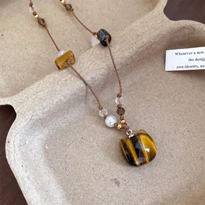 Vue détaillée d'un collier pendentif chat en œil de tigre avec perles
