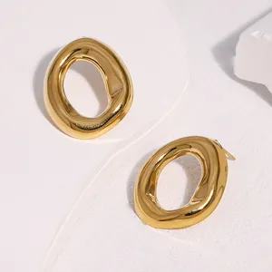 Detail view of gold minimalist irregular oval stainless steel stud earrings with texture