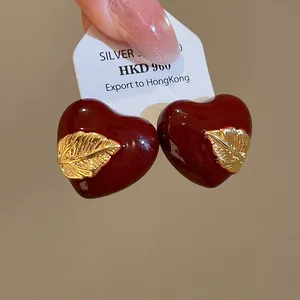 Detailansicht der 18k vergoldeten Herzohrstecker mit einem eleganten Blattakzent.