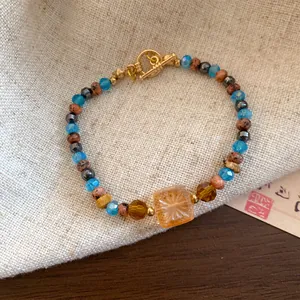 Handgemaakte kralenarmband in nieuwe Chinese stijl met gekleurde stenen en gouden sluiting.