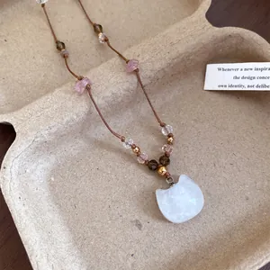 Détail d'un collier vintage style Maillard avec pendentif chat blanc et perles