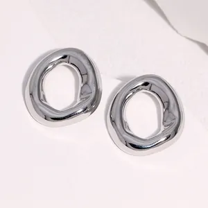 Close-up of minimalist silver geometric irregular circle stud earrings made of steel