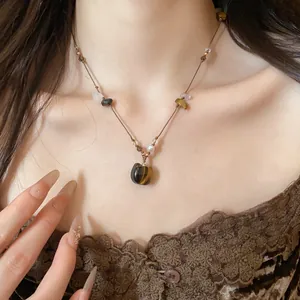 Détail d'un collier choker rétro style Maillard avec pendentif chat en pierre et perles