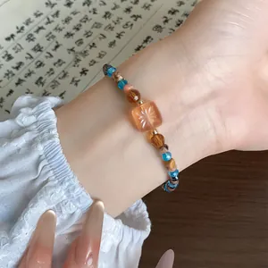 Gedetailleerd overzicht van kralenarmband in moderne Chinese stijl met oranje sterparel