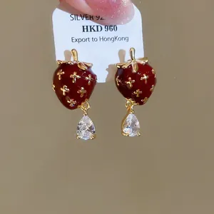 Detail showing vintage-style strawberry earrings with sparkling pear-cut zircon drops
