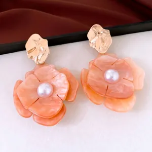 Elegant orange acrylic flower earrings with pearl center and gold wrinkle studs.