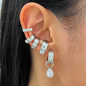 Gros plan détaillé sur un ensemble de bagues d'oreille argentées et boucle en zircon